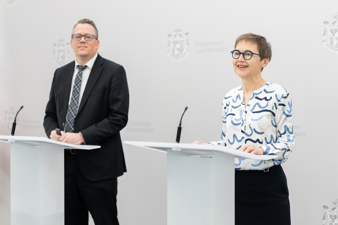 Ein Mann und eine Frau stehen vor einer grauen Wand