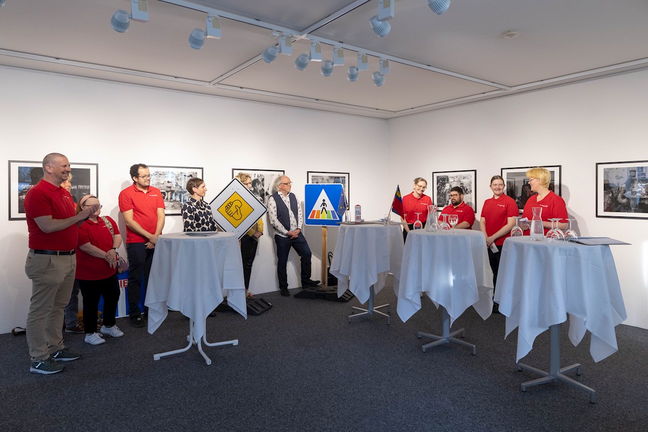 Das Team von Special Olympics Liechtenstein stellt sein Projekt vor. Die Teammitglieder stehen hinter mehreren Stehtischen und sind alle in rote Shirts gekleidet.