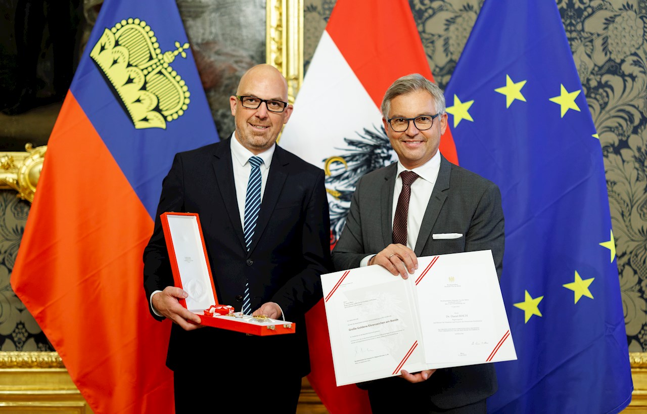 Daniel Risch hält Orden und steht neben Magnus Brunner