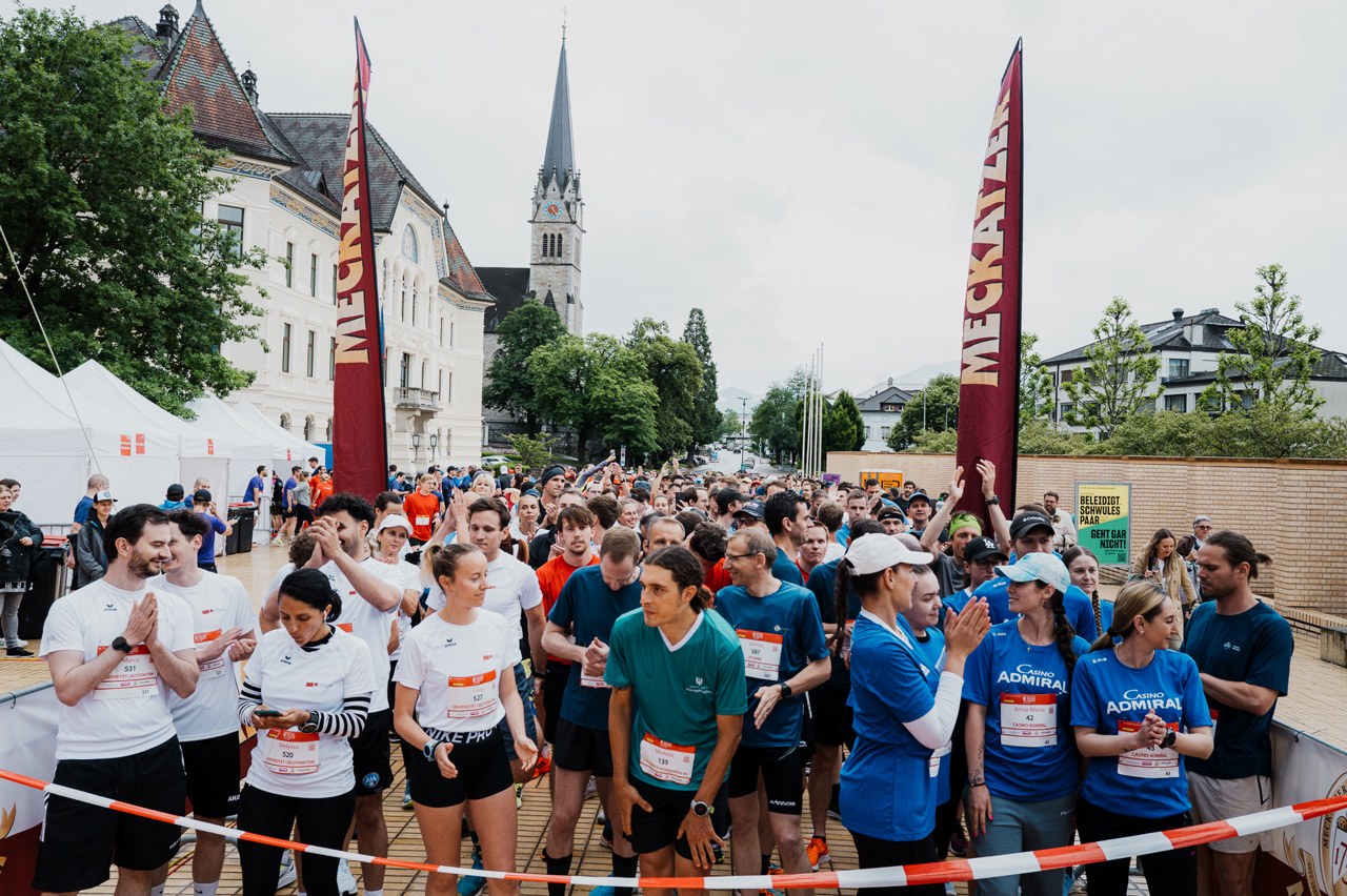 Viele Läuferinnen und Läufer stehen auf dem Peter-Kaiser-Platz. Im Hintergrund erkennt man die Kirche