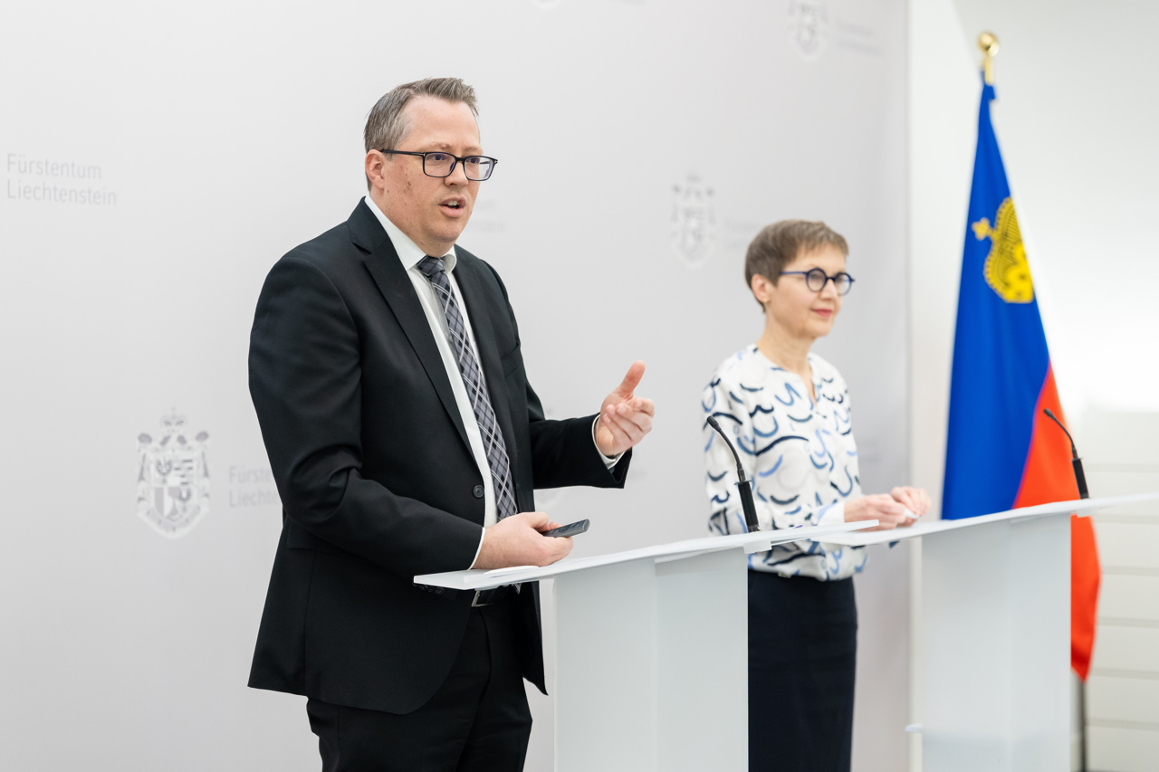 Ein Mann und eine Frau stehen vor einer grauen Wand